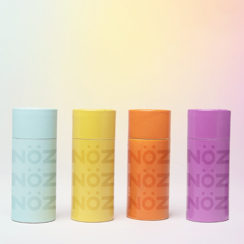 Four Nöz products standing in line from blue, yellow, orange, and purple from left to right